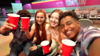 Çeşitli genç arkadaşlar selfie çekiyorlar, kırmızı bardaklardan içiyorlar, kahkahaları ve arkadaşlıkları paylaşıyorlar.