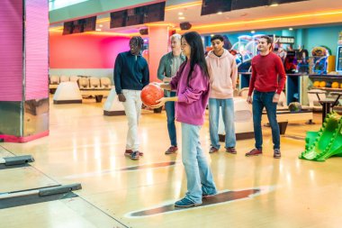 Çok ırklı arkadaşlar haftasonunu birlikte geçiriyorlar bowling oynuyorlar ve bowling salonunda eğleniyorlar.