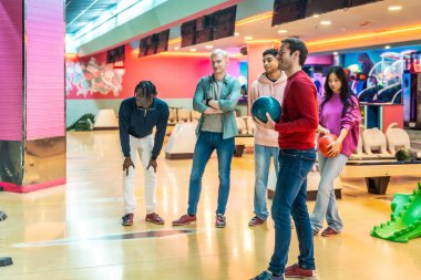 Çok ırklı arkadaşlar neşeli bir hafta sonunun keyfini çıkarıyorlar, neşeli, aydınlık bir sokakta bowling oynarken kahkaha ve heyecan paylaşıyorlar.