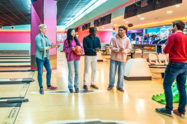 Beş genç çok ırklı arkadaş birlikte bowling oynuyorlar, konuşuyorlar ve eğleniyorlar.