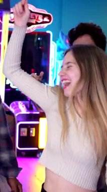 Genç arkadaşlar canlı bir enerjiyle dans ediyorlar, renkli atari salonlarını neşeli hareketlerle dolduruyorlar ve mutluluğu paylaşıyorlar.