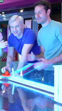 Havalı hokey maçında enerjik bir şekilde rekabet eden çoklu etnik arkadaşlarla canlı bir oyun sahnesi, kahkaha ve heyecan paylaşımı