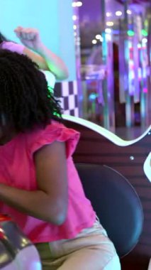 Atari yarışında arkadaşça bir yarışın keyfini çıkaran genç kadınlar, gülüşmeler ve tezahüratlar.