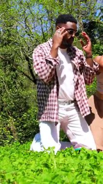 Çeşitli arkadaş grupları dans ediyor, neşeli anları paylaşıyor ve yaz güneşinin altında yemyeşil parklarda piknik yapıyor.