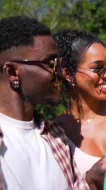 Neşeli bir grup güneşli öğleden sonranın tadını çıkarıyor, renkli içkileri paylaşıyor ve açık hava ortamında bulaşıcı enerjiyle dans ediyor, arkadaşlığı ve neşeyi kutluyor.