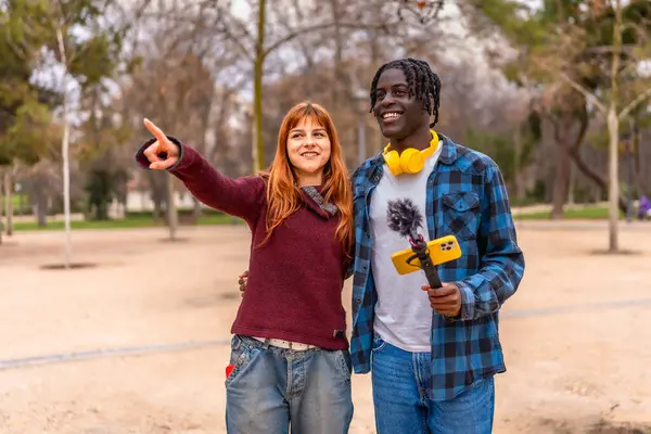 İki genç içerik yaratıcısı akıllı telefon ve mikrofon kullanarak sosyal medya kanalları için bir video kaydediyor.