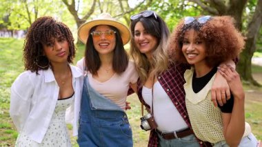 Genç turistlerin kaynaşması, bereketli park ortamında kucaklaşması, tatil sırasında arkadaşlık ve neşe paylaştığı bir an.