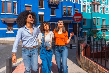 Canlı bir şehir caddesinde birlikte yürüyen üç neşeli arkadaş heyecanlı tatillerinin görüntülerini ve seslerini emdiler.