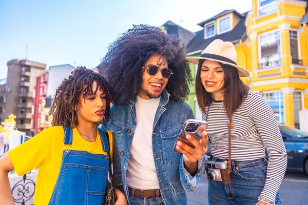 Turistler, Valparaiso, Chile 'deki canlı ve renkli evlerin önünde gülümseyip eğleniyorlar, akıllı telefonlarla anları yakalıyorlar.