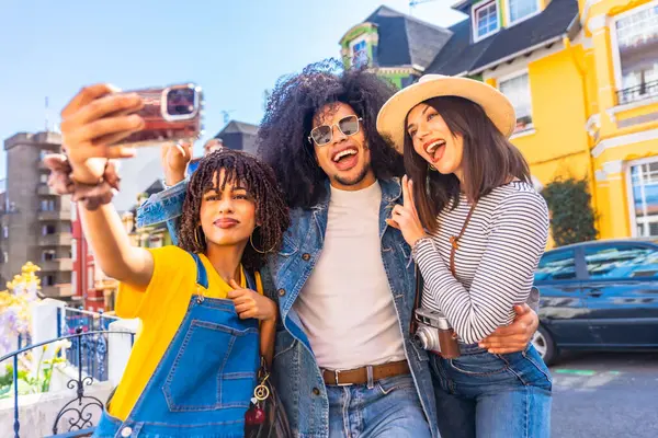 Üç mutlu turist, Valparaiso ve Şili 'nin renkli evlerini ziyaret ederken bir aksiyon kamerasıyla selfie çekiyorlar.