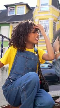 Genç arkadaşlar şehir basamaklarında otururken gerçek kahkahaları paylaşıyorlar, sıcak gündüz saatlerinde canlı sohbetler yapıyorlar.