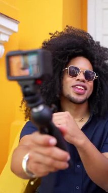 Genç içerik yaratıcısı arkadaşlarının renkli milkshake 'lerini kaydederken aynı zamanda canlı sarı kapı eşiğinde takılıyor, spontane yaz arkadaşlığı ve boş zamanlarını yakalıyor.