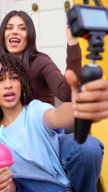 Genç içerik yaratıcıları, yaratıcı kentsel yaşam tarzı oturumları sırasında milkshake içerken profesyonel jimnastik kullanarak video blogu paylaşımında işbirliği yapıyorlar.