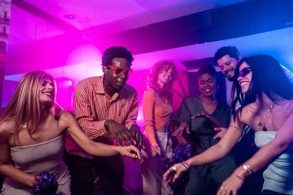 Bir grup çok ırklı arkadaş diskoda eğleniyor, dans ediyor ve birlikte eğleniyorlar.