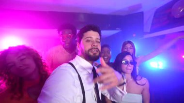 Mutlu çoklu etnik arkadaşlar dans ederken ve gece klübünde eğlenirken selfie çekiyorlar.