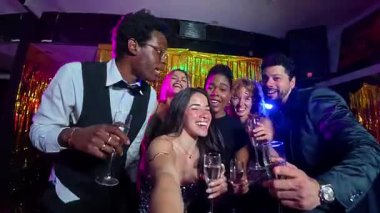 Neşeli arkadaşlar yeni yıl partisinde selfie çekiyorlar, içkilerin ve neşeli atmosferin tadını çıkarıyorlar.