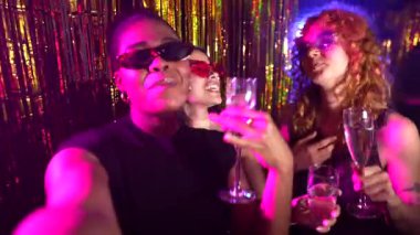 Genç kadınlar, arkadaşlarıyla coşkulu gece klübü kutlamalarında kokteyllerini yudumlarken ve hatıralarını yakalıyorlar.