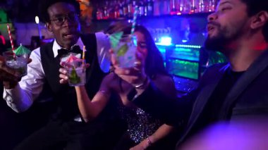 Neşeli çok kültürlü arkadaşlar selfie çekiyorlar, kokteyl içiyorlar ve birlikte unutulmaz sosyal anları yakalarken canlı bir gece kulübü atmosferinin tadını çıkarıyorlar.