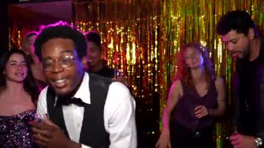 Arkadaşlar enerjik bir dansla kutlama yapıyorlar. Parlayan altın zemine karşı kokteyller hazırlıyorlar. Neşeli gece hayatını paylaşıyorlar.