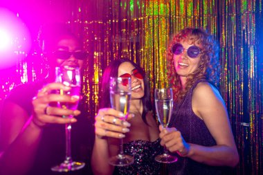 Üç çok ırklı kadın bir gece kulübünde şampanya bardaklarıyla kadeh kaldırıyor ve gece hayatının tadını çıkarıyorlar.