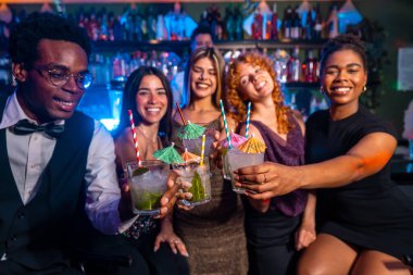 Çeşitli arkadaş grupları coşkulu bir gece kulübünde mojito kadehleri kaldırarak gece hayatı ve arkadaşlığın tadını çıkarıyor.