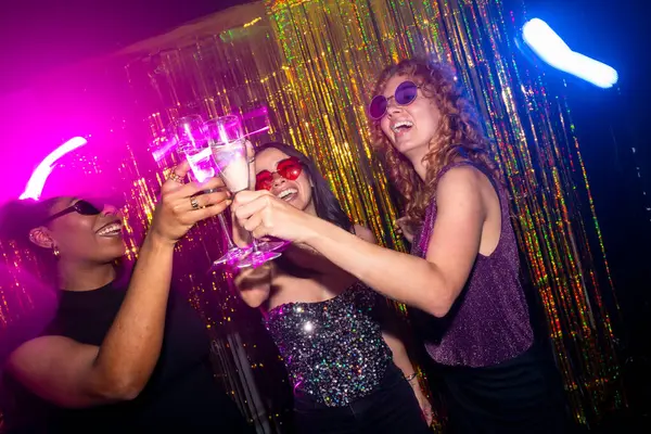 Üç çok ırklı bayan arkadaş şampanya bardaklarıyla kadeh kaldırıyor. Canlı bir disko partisinde gece hayatı ve müziğin tadını çıkarıyorlar.
