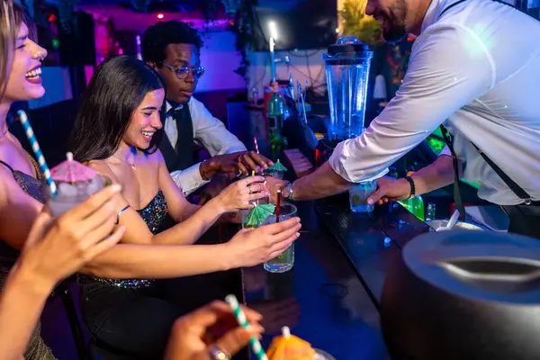 Neşeli barmen, mutlu çoklu etnik arkadaşlara kokteyl veriyor. Gece hayatının tadını çıkarıyor.
