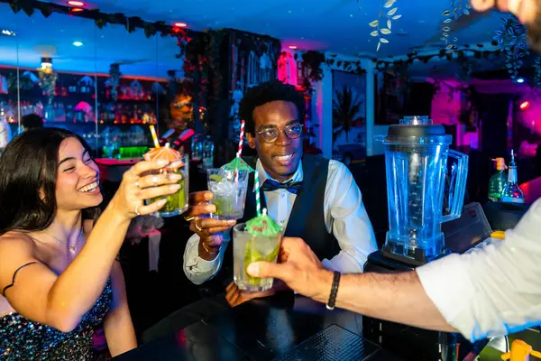 Mutlu arkadaşlar canlı bir tropikal barda birlikte kokteyl içip arkadaşlığımızı ve iyi zamanlarımızı kutluyorlar.