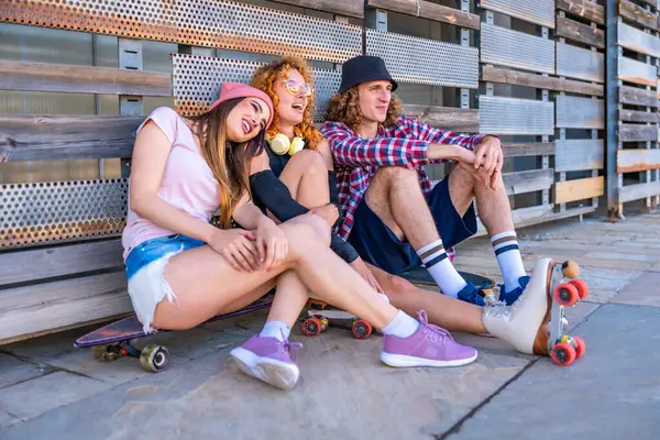 Üç arkadaş paten yapmaya ara veriyor, bankta birlikte oturuyor, kahkahalarını paylaşıyor ve şehirde kaygısız bir anın tadını çıkarıyor.