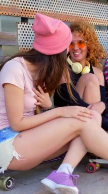 Bir grup neşeli arkadaş, kaykayların üzerinde oturmuş, genç enerjisi ve arkadaşlığı somutlaştırırken birbirlerinin yanında eğleniyorlar.