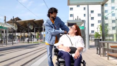 Değer veren erkek arkadaş, kız arkadaşına destek oluyor. Kentsel ulaşım platformunda tekerlekli sandalye kullanıyor. Derin duygusal bağlar ve kapsayıcılık sergiliyor.