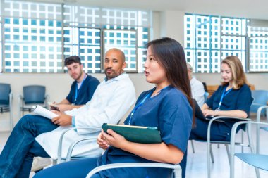 Bir tıp konferansına katılan, aktif olarak tartışmalara katılan ve notlar alan çeşitli sağlık hizmetleri uzmanları grubu