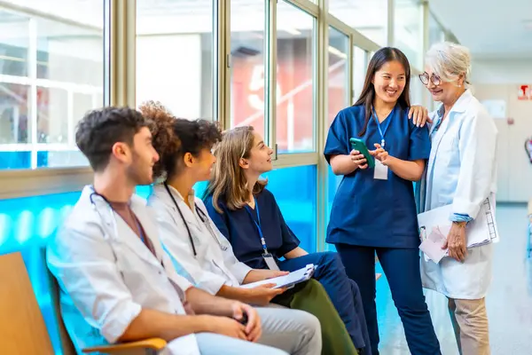 Doktorlar ve hemşireler akıllı telefondaki tıbbi kayıtları inceliyor, hastane ortamında işbirliği ve iletişimi teşvik ediyor.