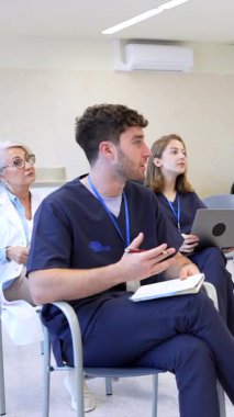 Doktorlar ve hemşireler bir tıp konferansına katılıyor, aktif olarak tartışmalara katılıyor ve notlar alıyorlar.