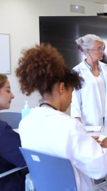 Doktorlar ve tıp uzmanları, modern bir hastane ortamında, hasta verilerini analiz ediyor ve tedavi planları hazırlıyor.