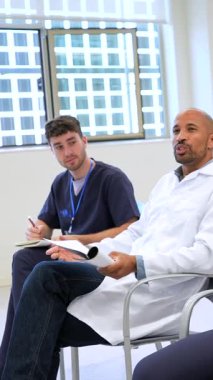 Çeşitli sağlık hizmetleri uzmanları, parlak, modern bir toplantı odasında yapılan eğitim oturumunda canlı bir tartışmaya giriştiler.