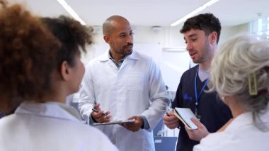 Doktorlar ve hemşireler iş birliği yapıyor, görüşlerini paylaşıyor ve hastane toplantısında hasta bakımı için önemli kararlar veriyorlar.