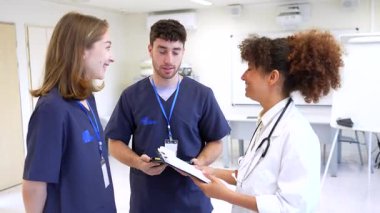 Doktorlar ve hemşireler, modern bir hastane ortamında en uygun hasta bakımına ilişkin görüş ve uzmanlıklarını paylaşarak işbirliği yaparlar.