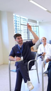 Doktorlar ve hemşireler, tıbbi bir konferans sırasında aktif olarak bilgi paylaşımını ve işbirliğini teşvik etmek amacıyla bir oturum düzenlerler.