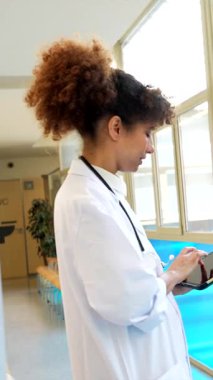 Hastane koridorundaki sağlık hizmetleri konsültasyonu sırasında dijital tablet kullanırken hastayla ilgilenen, modern tıbbi iletişim ve hasta etkileşimini gösteren tıbbi uzmanlar