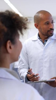 Çeşitli tıp uzmanları aktif olarak ortak bir tartışmada yer alıyor, görüşleri paylaşıyor ve hastane ortamında notlar alıyorlar.