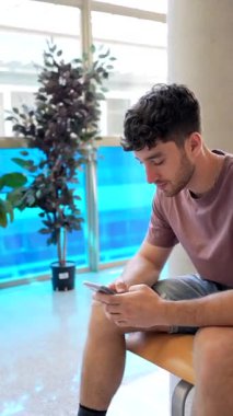 Tıp fakültesinde bekleyen genç bir profesyonel doktorla görüşmeden önce akıllı telefon kullanıyor ve sağlık sorunlarını tartışıyor.