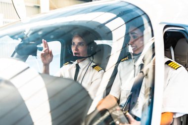 İki kadın pilot, özel bir uçağın kokpitinde kalkışa hazırlanıyor.