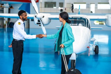 Pilot ve iş kadını bir hangarın içinde özel bir jetin önünde el sıkışıyor ve ayrılmadan önce ortaklıklarını bitiriyorlar.