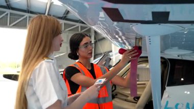 Kadın havacılık bakımı stajyeri eğitmeninin gözetiminde uçuş öncesi denetim prosedürlerini öğreniyor.