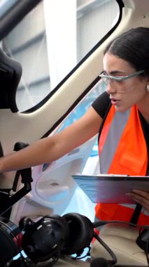 Kadın uçak bakım mühendisi, uçuş öncesi kontrol sırasında bir helikopterin kokpit aletlerini titizlikle inceliyor ve optimum işlevsellik ve güvenlik sağlıyor.