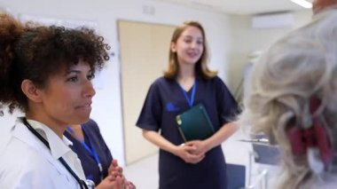Hastane toplantısında iş birliği yapan tıp uzmanları, çeşitli doktor ve hemşirelerle parlak konferans odasında hasta bakımını tartıştılar.