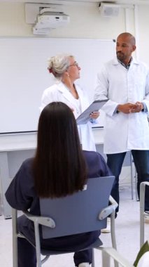 Doktorlar, modern bir sınıf ortamında çeşitli sağlık uzmanlarına bilgi sunuyor.