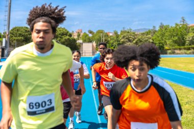 Çeşitli sporcular coşkulu bir mavi pistte, sınırlarını zorluyor ve heyecan verici bir yarışta zafer için mücadele ediyorlar.