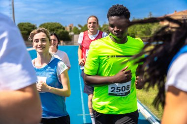 Canlı bir mavi pistte yarışan koşucular zafer için azim ve çabalarını sergiliyorlar.